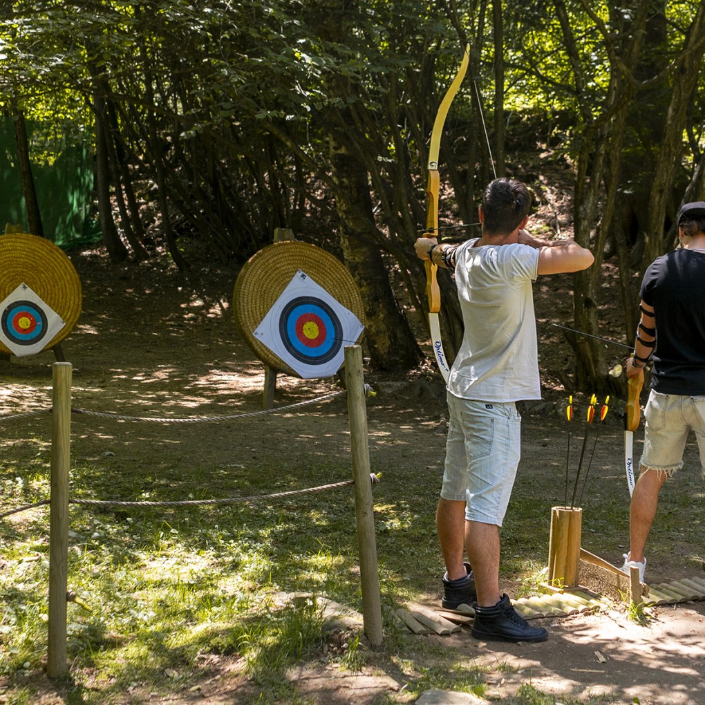 Due ragazzi si divertono provando il tiro con l'arco al parco avventura in Lombardia
