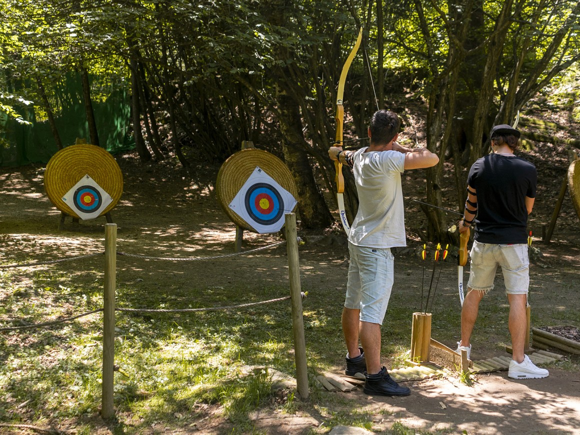 Due ragazzi si divertono provando il tiro con l'arco al parco avventura in Lombardia