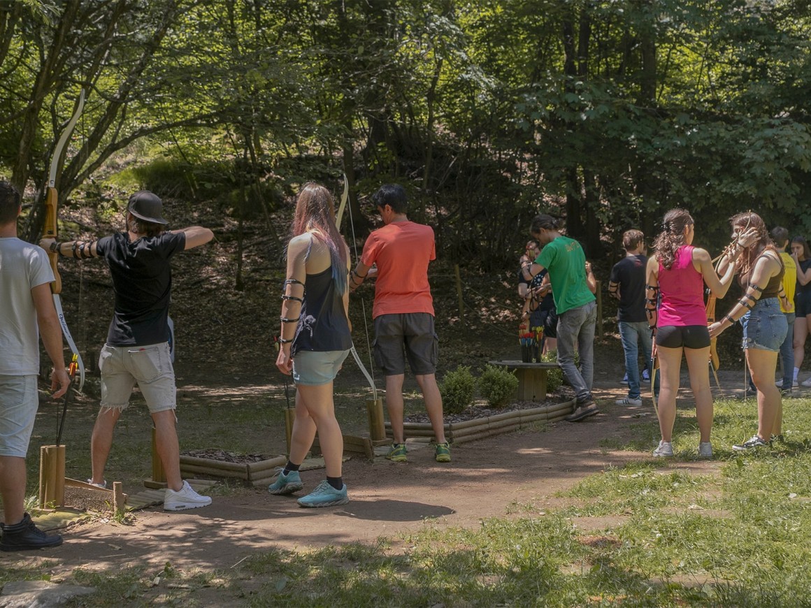 Gruppo si diverte provando il tiro con l'arco al parco avventura in Lombardia