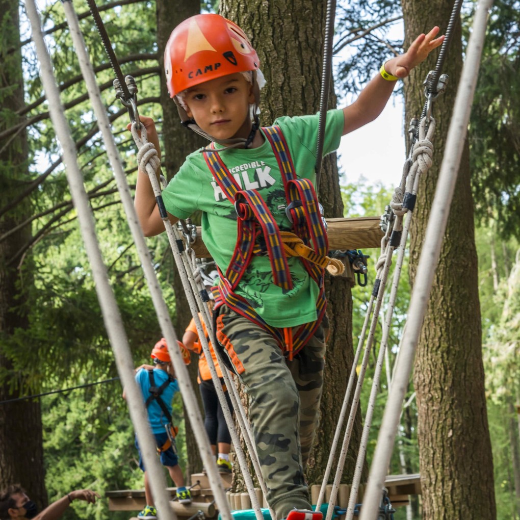Bambino supera il percorso con altalene verticali al Jungle Raider Park