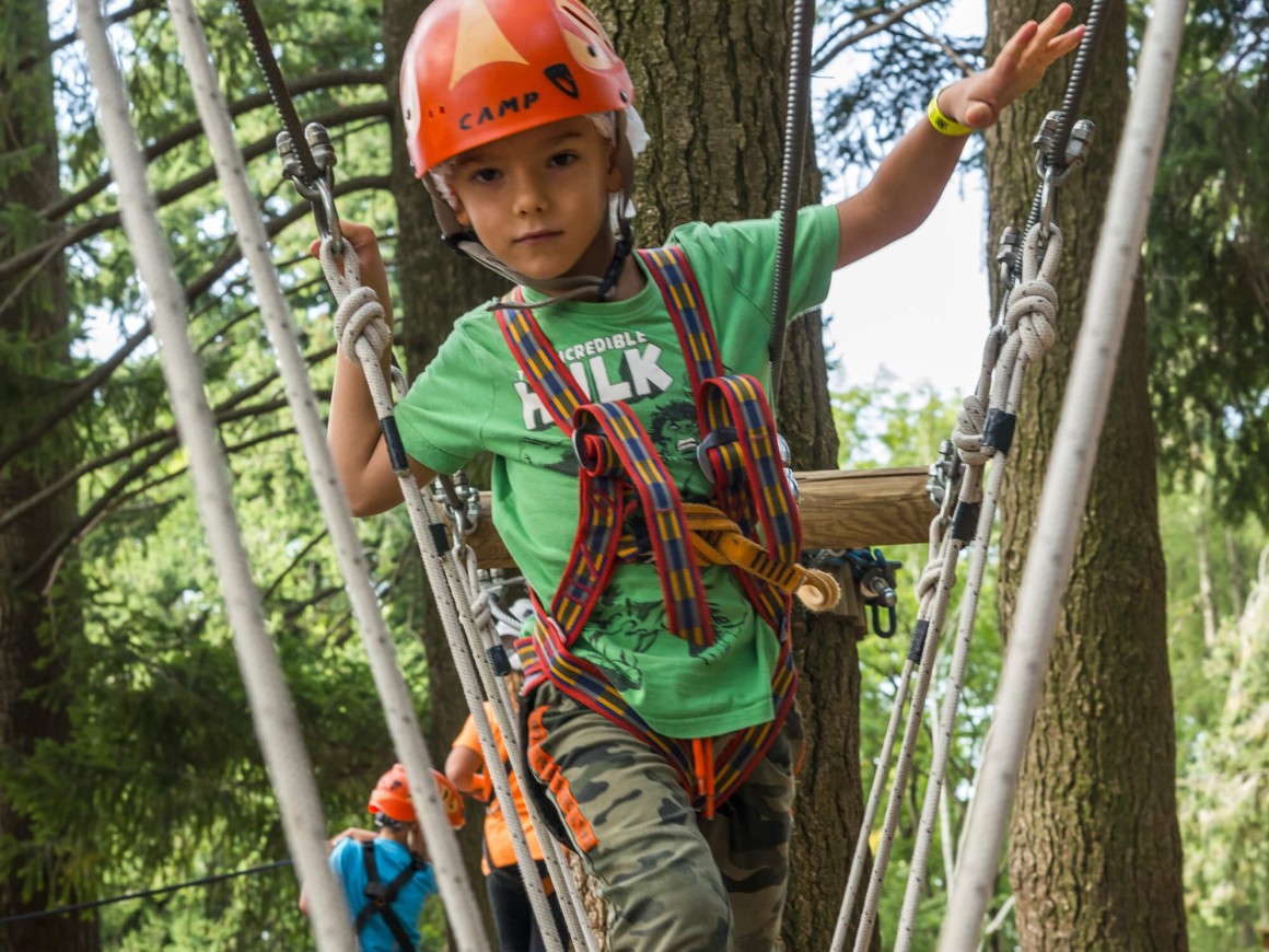 Bambino supera il percorso con altalene verticali al Jungle Raider Park