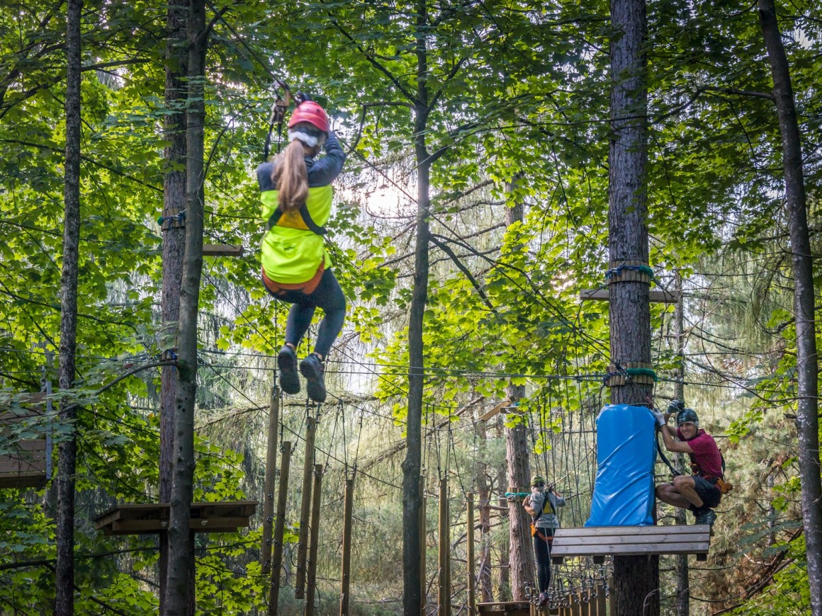 Ragazza su zipline al parco avventura vicino a Como