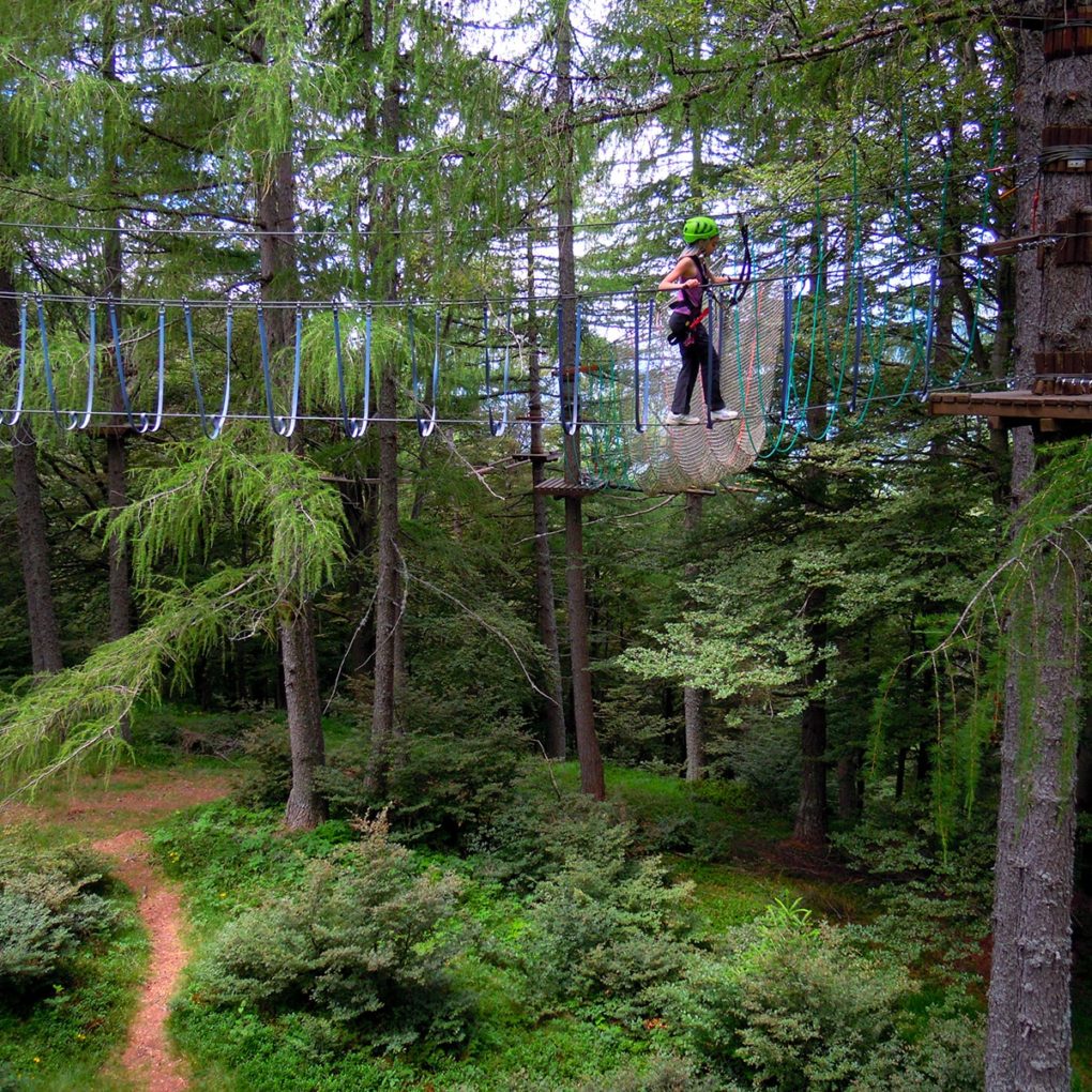 Ponte tibetano tra gli alberi del parco avventura per ragazzi e adulti